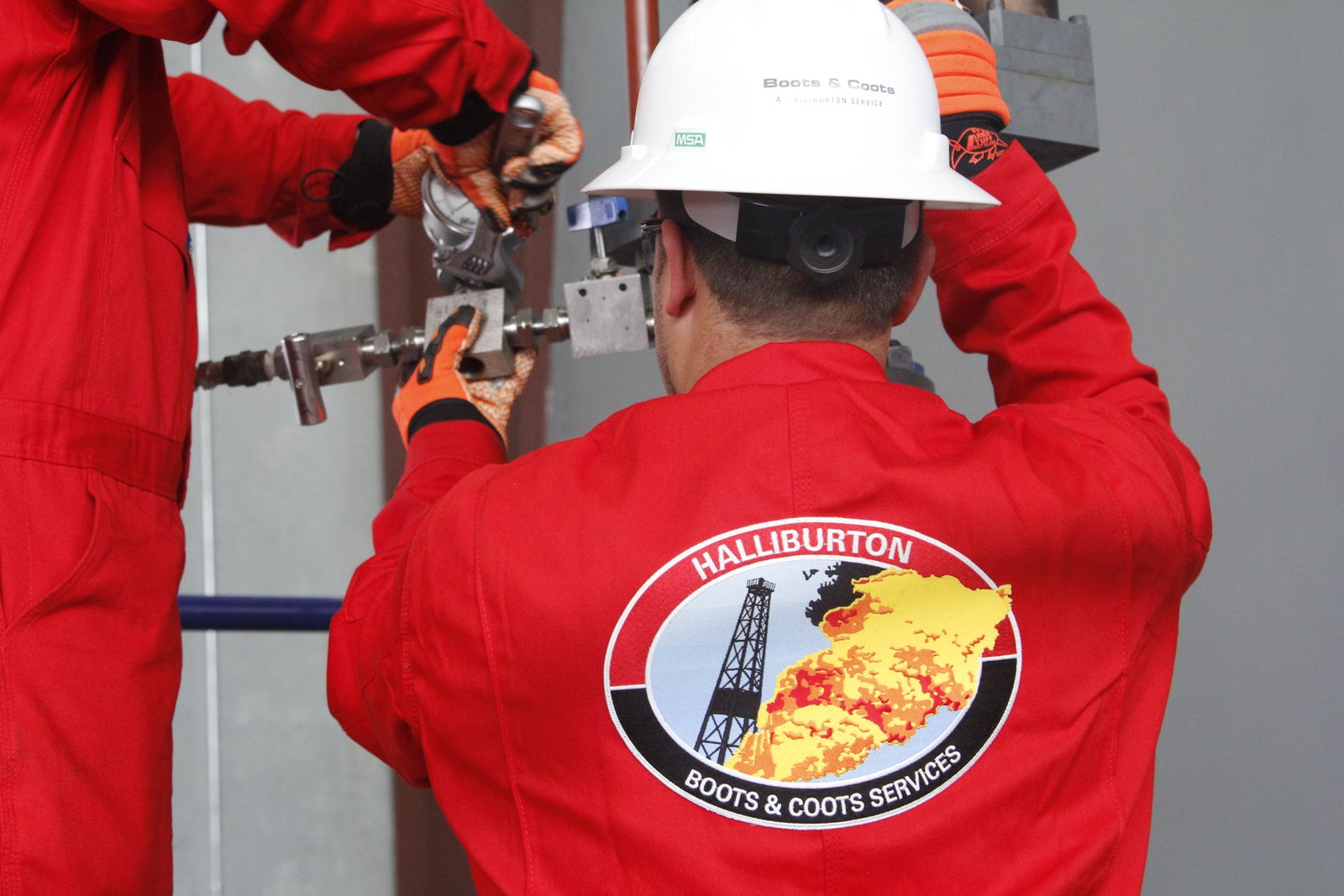Halliburton Boots & Coots employees working on a wellhead.