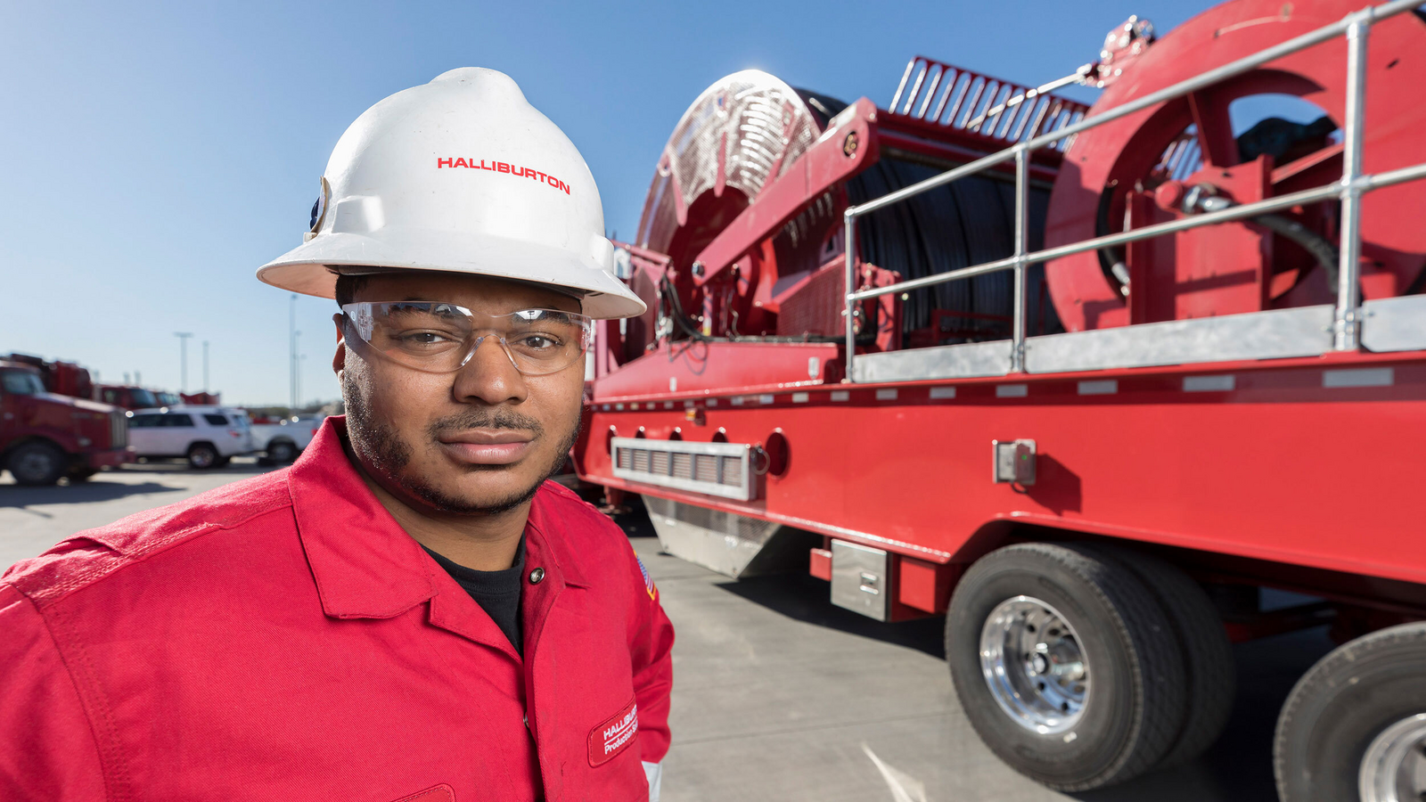 Halliburton employee in the field standing in front of equipment